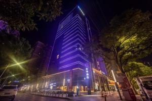 a tall building with blue lights on it at night at Ji Hotel Changde Hunan Wenli College in Changde
