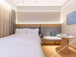 a bedroom with a large bed and a table at JI Hotel Lanzhou University Donggang West Road in Baidaoping