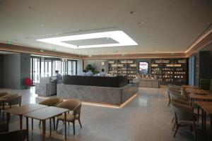 a restaurant with tables and chairs and a library at Ji Hotel Jinzhou Red Star Macalline in Jinzhou