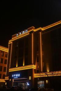 a building with chinese writing on it at night at Ji Hotel Jinzhou Red Star Macalline in Jinzhou