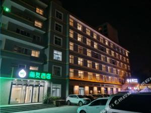 een gebouw waar auto's voor geparkeerd staan bij Hi Inn Xining Mojia Street in Xining