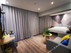 a hotel room with a bed and a couch at Hi Inn Xining Mojia Street in Xining
