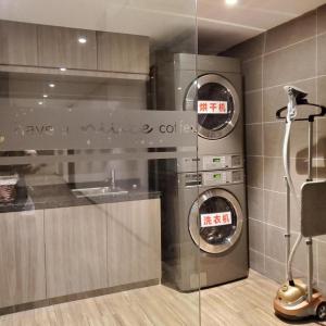 een keuken met 2 wasmachine en droger in een kamer bij Hanting Hotel Qingdao Xianggang Zhong Road Aofan Center in Qingdao