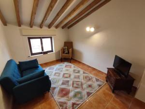 a living room with a blue couch and a television at The Loft Pinoso in Pinoso