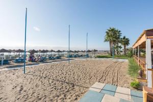 - un terrain de volley-ball sur une plage de sable avec des parasols dans l'établissement Sea view Apartment w/ 2 rooms, Beach: 1 minute, à Torremolinos