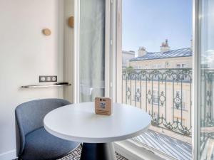 a white table and chair in front of a window at ibis Paris Père Lachaise in Paris