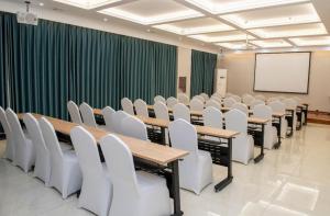 a conference room with tables and white chairs at Hanting Hotel Cixian Yizhong in Cizhou