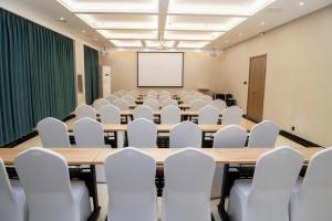 a conference room with tables and chairs and a whiteboard at Hanting Hotel Cixian Yizhong in Cizhou
