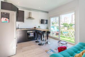 Il comprend un salon avec un canapé bleu et une cuisine. dans l'établissement Sea view Apartment w/ 2 rooms, Beach: 1 minute, à Torremolinos