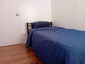 ein Bett mit blauer Decke in einem Schlafzimmer in der Unterkunft Condotel 2 bedroom with terrace and free car parking in Naga