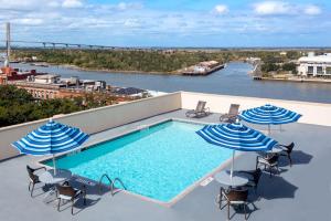 a swimming pool with chairs and umbrellas on a roof at Hampton Inn Savannah Historic District in Savannah