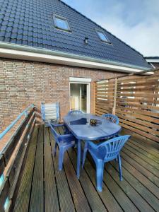 ショルテンスにあるGroße familienfreundliche Wohnung mit Balkonの木製デッキ(青いテーブルと椅子付)