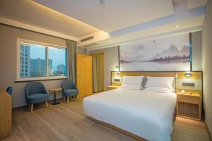 Starway Hotel Linhai Yintai City tesisinde bir odada yatak veya yataklar