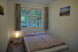 um quarto com uma cama em frente a uma janela em Ruheoase am Wald 35651 em Uplengen