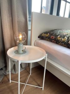 Charmante Wohnung im Hinterhof في نويكيرشن-فلوين: طاولة بيضاء عليها شمعة بجانب السرير