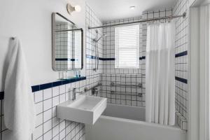 a white bathroom with a sink and a tub at The Variety by LuxUrban in Miami Beach