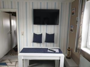 einen weißen Tisch mit einem TV an der Wand in der Unterkunft Ferienhaus in Sassnitz - klein aber fein bis 4 Personen in Sassnitz