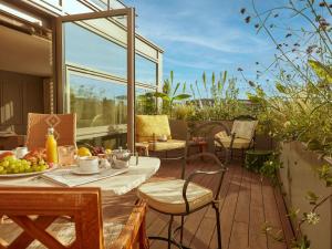 d'une terrasse avec une table et des chaises sur un balcon. dans l'établissement Mondrian Bordeaux Les Carmes, à Bordeaux