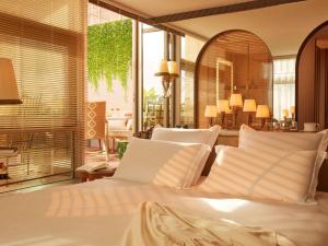 1 dormitorio con cama blanca y almohadas blancas en Mondrian Bordeaux Les Carmes, en Burdeos