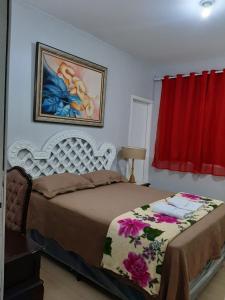 烏巴雅拉的住宿－Pousada e Museu JK，卧室配有一张床,墙上挂有绘画作品