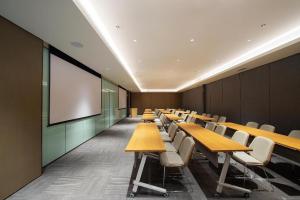 a conference room with tables and chairs and a screen at Ji Hotel Shenyang Zhong Street Gugong in Shenyang