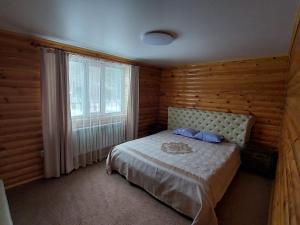 a bedroom with a bed and a large window at Krona Borovoe in Barmashino