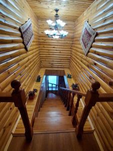 a wooden room with a table and a chandelier at Krona Borovoe in Barmashino