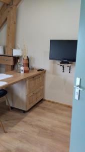an office with a desk and a tv on a wall at Gîte de l'Orme L'Horizon in Nanteau-sur-Essonnes