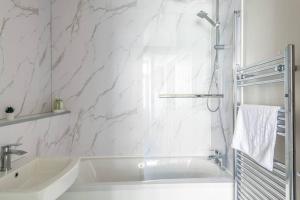 a white bathroom with a tub and a sink at Newly Renovated Upnor House with 2 Free Parking by Prescott Apartments in Bristol