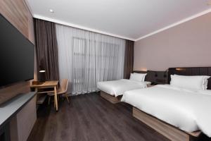 Ein Bett oder Betten in einem Zimmer der Unterkunft Hanting Premium Hotel Xi'an Dayan Tower Nan PlazaBayi Road Minhang Tower
