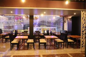 a dining room with tables and chairs and a window at Balaji gold inn hotel in Hubli