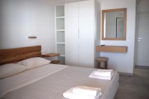 Κalamitsi Rooms & Apartments في كيمولوس: غرفة نوم عليها سرير وفوط