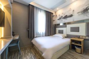 מיטה או מיטות בחדר ב-Hi Inn Shanghai Xujiahui Yongjia Road