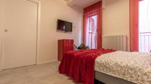 um quarto com uma cama com um cobertor vermelho em Suite Modena al Centro - Affitti Brevi Italia em Módena