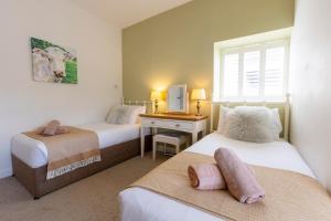 a bedroom with two beds and a desk with a mirror at Westfield Granary in Ganton