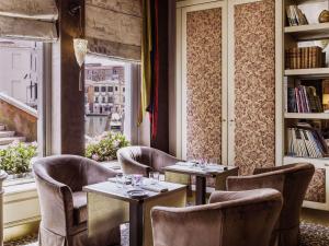 a restaurant with two tables and chairs and a window at Papadopoli Hotel Venezia - MGallery Collection in Venice