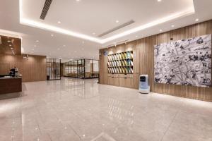 a large lobby with a large painting on the wall at Hanting Premium Hotel Taizhou Wanda Plaza in Taizhou