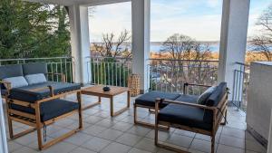 a porch with chairs and a table on a balcony at LIBORIA I Villa mit Seeblick 10min vom See in Herrsching am Ammersee