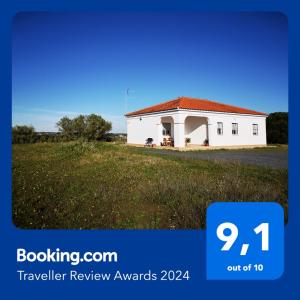 a white building with a red roof on a field at Casa Rural Cerca de la Playa El Rompido in El Rompido