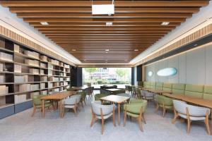 a library with tables and chairs and books at Ji Hotel Suqian Sucheng District Government in Suqian