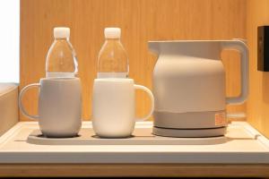 three bottles of milk and a pitcher on a shelf at Ji Hotel Suqian Sucheng District Government in Suqian