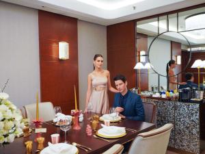 un hombre y una mujer sentados en una mesa en un restaurante en Admiral Hotel Manila - MGallery en Manila