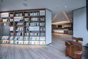 a library with book shelves filled with books at Hanting Hotel Shenyang Jiangdong Street Metro Station in Shenyang