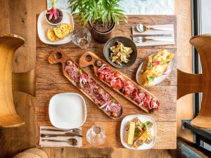 una mesa de madera con platos de comida. en Novotel Avignon Nord en Sorgues