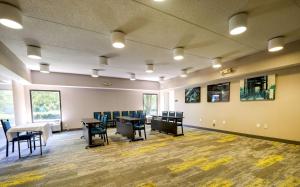 a waiting room with tables and chairs in a building at Hampton Inn Flemington in Flemington