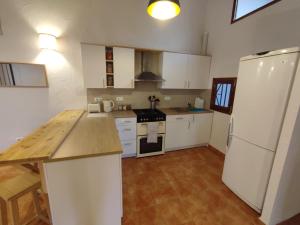 a kitchen with white cabinets and a white refrigerator at The Loft Pinoso in Pinoso