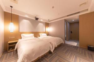 Ein Bett oder Betten in einem Zimmer der Unterkunft Hanting Premium Hotel Wenzhou Longwan Haicheng