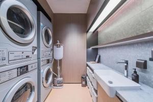 a laundry room with a sink and washing machines at Ji Hotel Shanghai Lujiazui World Plaza in Shanghai