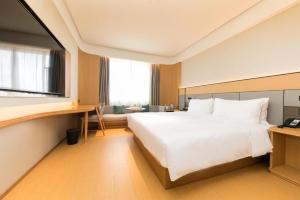 南京的住宿－Ji Hotel Nanjing Commercial Building，卧室配有一张白色大床和一张书桌