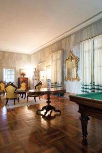 uma sala de estar com mesa de bilhar e cadeiras em Castello di Lispida em Monselice